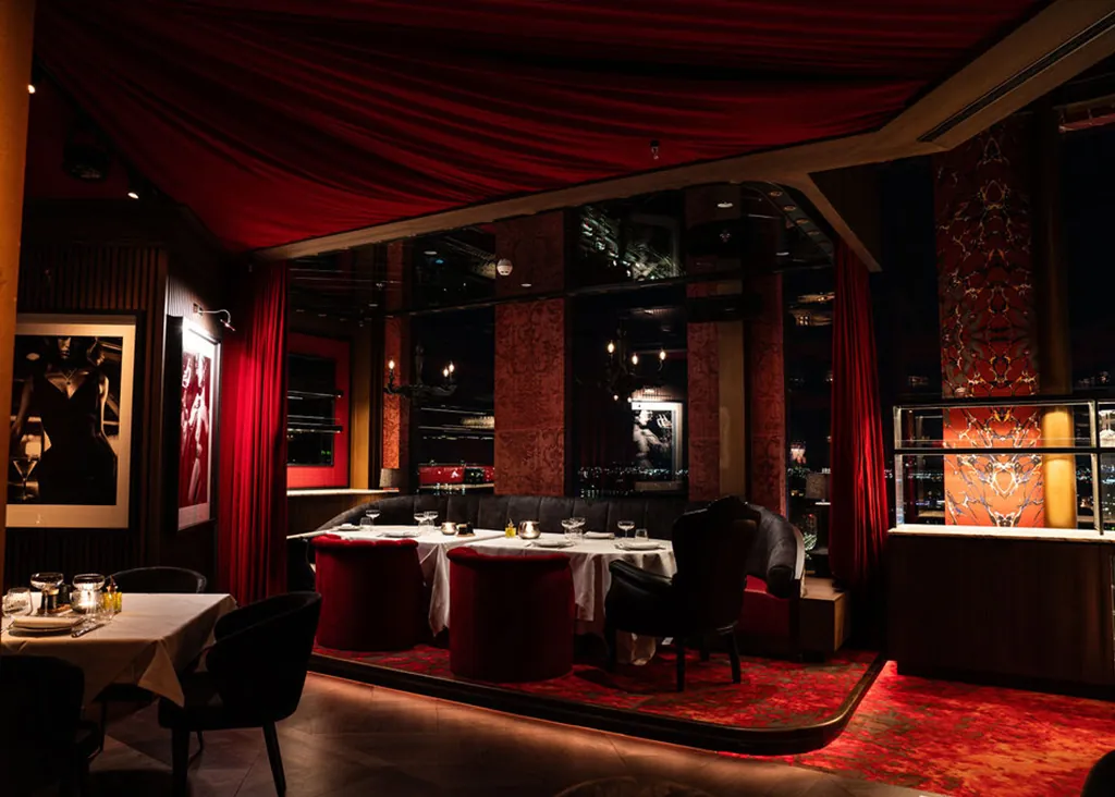 De dinerzaal van Ventuno met fluwelen gordijnen en gedekte tafels