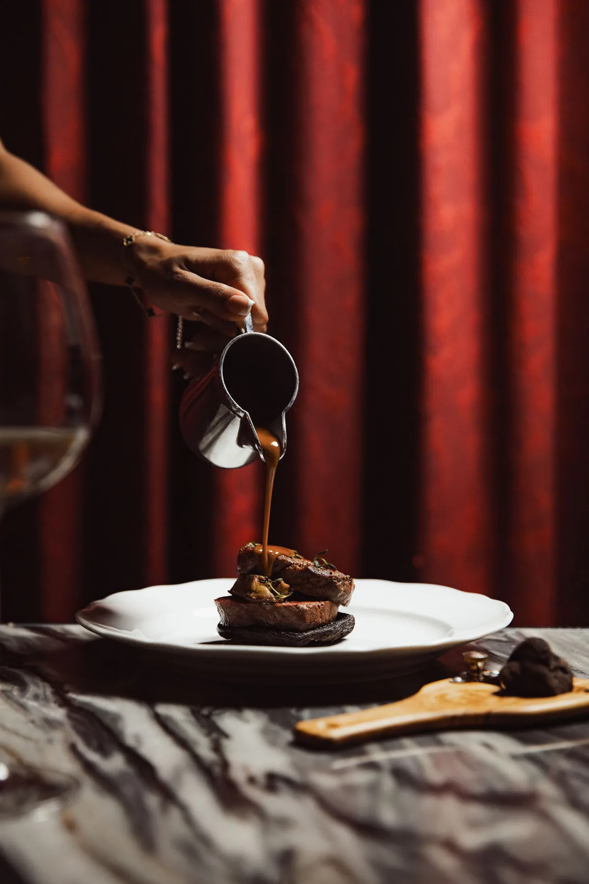 Saus wordt aan tafel over een gerecht geschonken